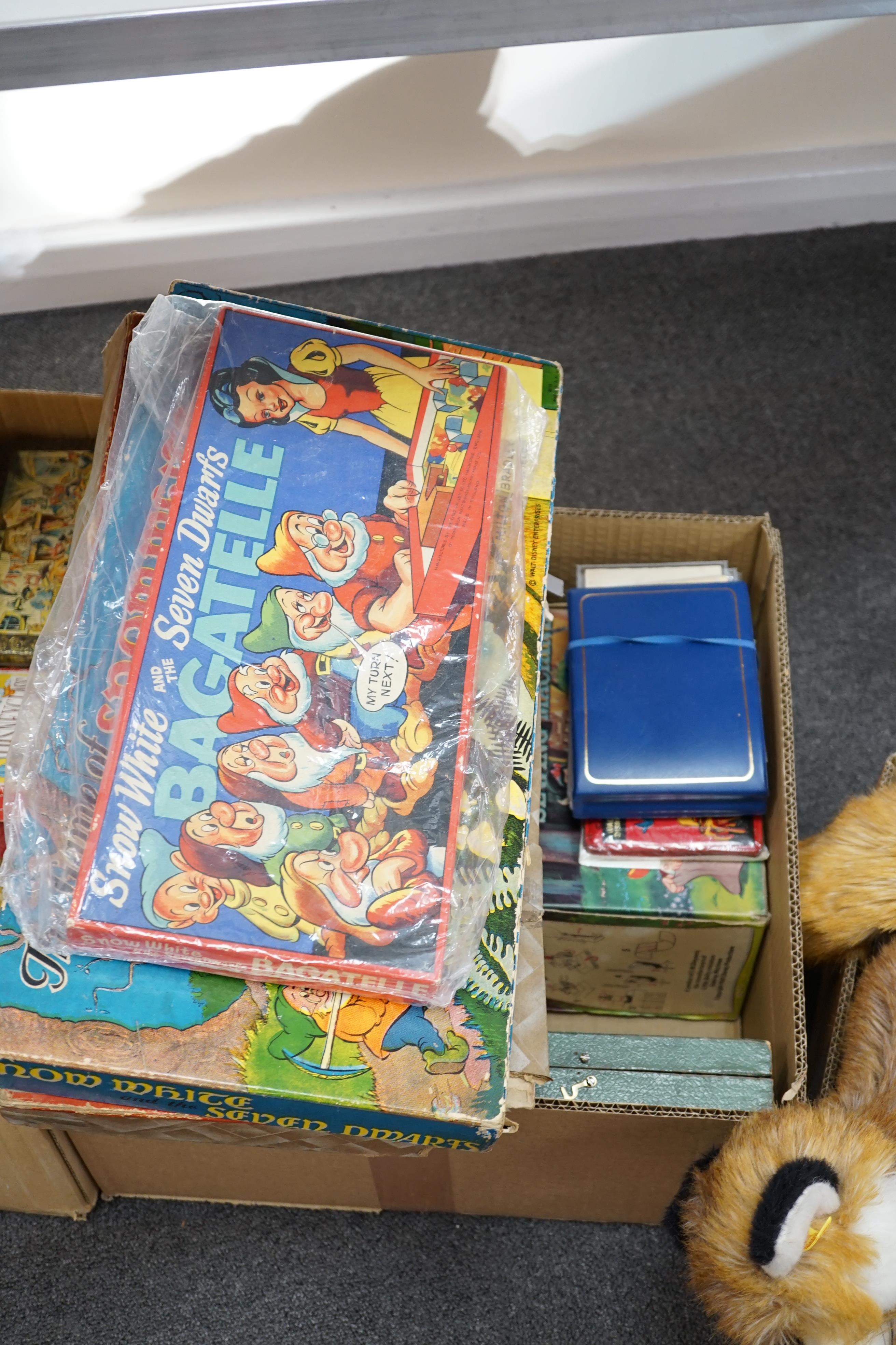 A collection of Disney Snow White memorabilia including; board games, a bagatelle board, jigsaw puzzles, The Seven Dwarfs Shooting Game, a Snow White sewing machine, ‘snap-apart’ soap, cake frills, handkerchiefs, books,